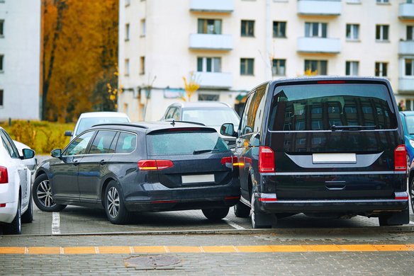 Parkrempler zwischen zwei Fahrzeugen auf einem Parkplatz