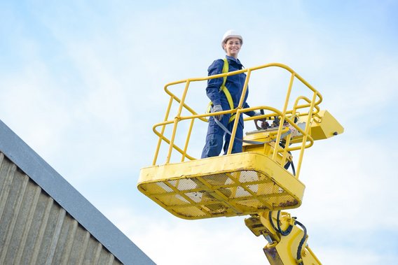 Arbeiter in Sicherheitskleidung auf einer Hebebühne während einer Schulung.