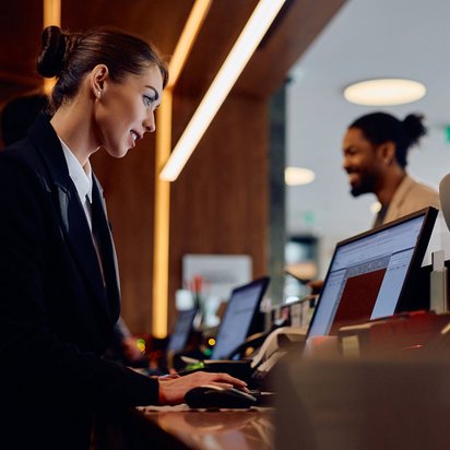 Rezeptionistin arbeitet an einem Computer in einem Hotel
