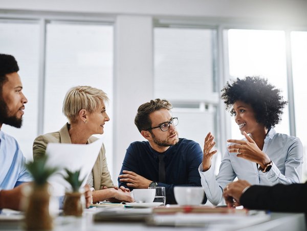 Fünf Personen im Meeting – symbolisiert individuelle Weiterbildungsangebote für Unternehmen durch TÜV NORD Akademie