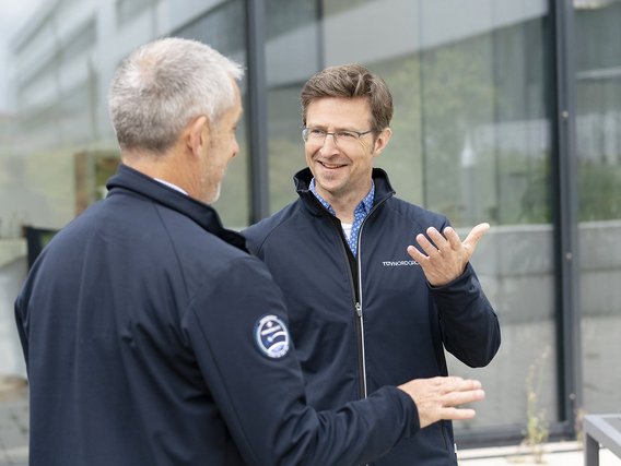 Zwei Mitarbeitende der TÜV NORD im Gespräch bezüglich Zertifzierung