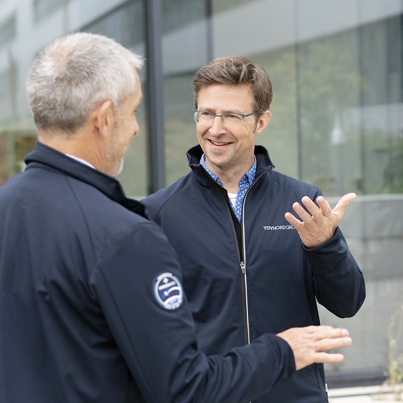 Zwei Mitarbeitende von TÜV NORD sprechen über Themen rund um Zertifizierung Zwei Mitarbeitende von TÜV NORD sprechen über Themen rund um Zertifizierung