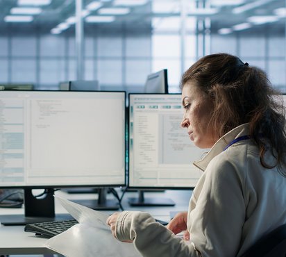 Hände tippen auf einer Laptop-Tastatur, umgeben von schwebenden digitalen Ordner- und Dokumentensymbolen.