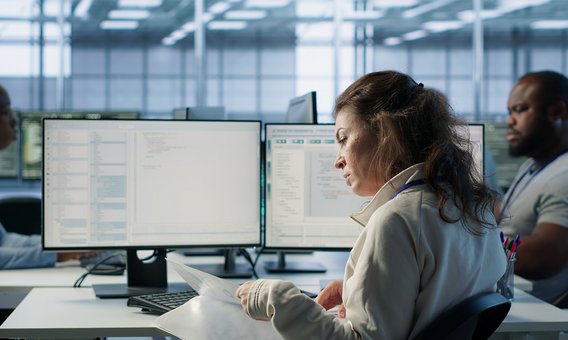 Hände tippen auf einer Laptop-Tastatur, umgeben von schwebenden digitalen Ordner- und Dokumentensymbolen.