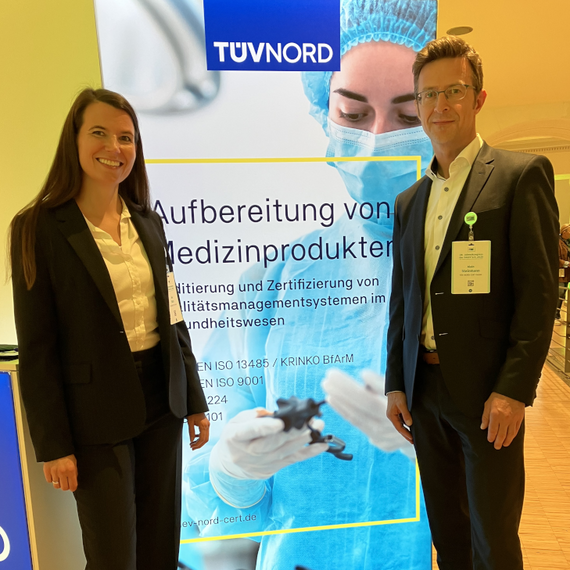 Nina Marx und Dr. Alain Steinmann vor dem TÜV NORD Stand 