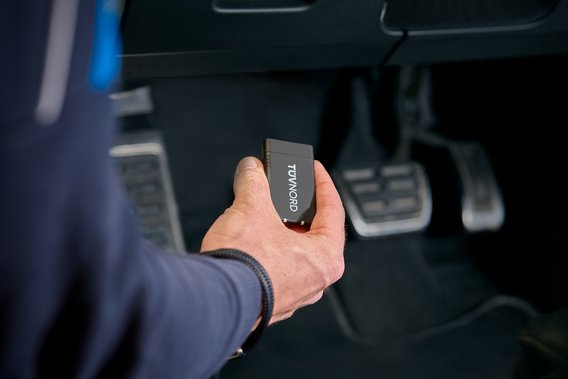Prüfingenieur hält TÜV NORD Onboard Diagnose im Fahrzeug