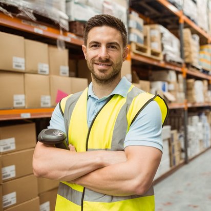 Effizientes Lagerverwaltung: Der Schlüssel zu erfolgreicher Logistik Lagerarbeiter in Sicherheitsweste steht in einem gut organisierten Lager voller Kartons.