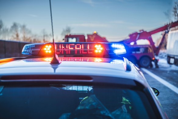 Polizeifahrzeug mit eingeschaltetem Blaulicht und Unfallwarnung