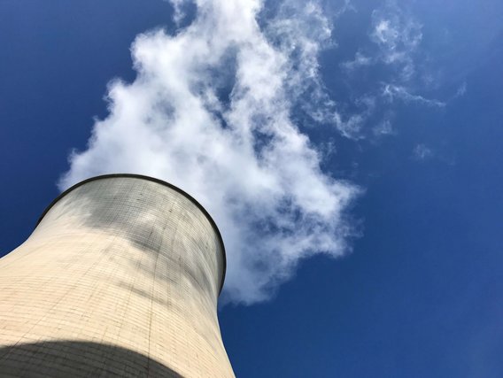 Kühlturm eines Kernkraftwerks vor blauem Himmel Typischer Kühlturm eines Kernkraftwerks – aufsteigender Dampf vor klarem Himmel symbolisiert industrielle Energieerzeugung.