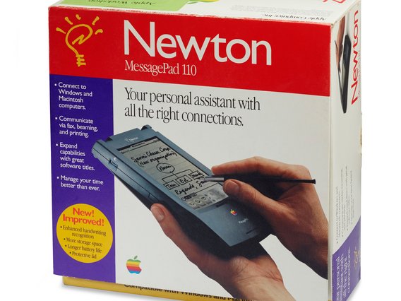 Die Verpackung eines Newton MessagePad 110 von Apple, einem PDA aus den 1990ern. Das rote Design zeigt eine Hand, die mit einem Stylus auf dem Gerät schreibt.