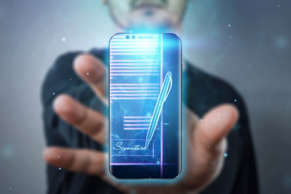 Hand hält Smartphone mit digitalem Dokument und Signatur-Symbol.