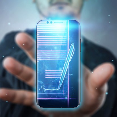 Hand hält Smartphone mit digitalem Dokument und Signatur-Symbol.