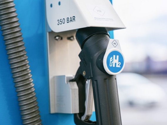 Eine Wasserstoff-Tankstelle mit einem Zapfhahn, der mit "H2" gekennzeichnet ist. Auf dem Gerät ist "350 BAR" zu lesen, was den Druck anzeigt.