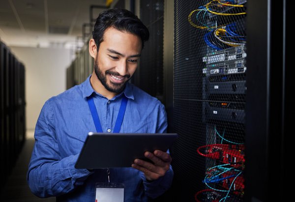 IT-Techniker prüft mit Tablet die Systeme in einem Rechenzentrum.
