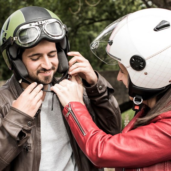 Zwei Personen beim Anpassen eines Motorradhelms