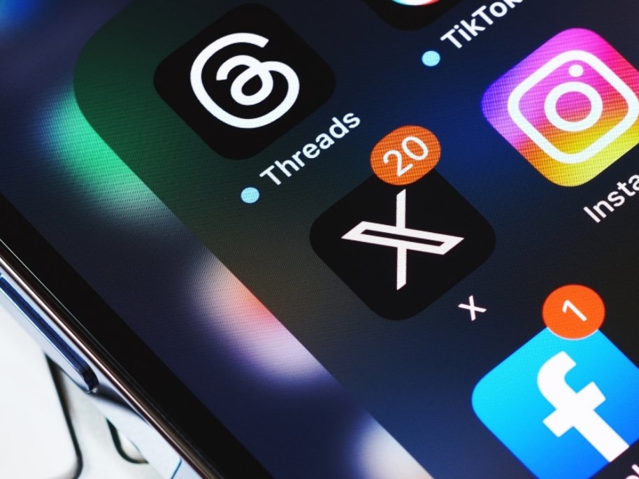 Smartphone-Bildschirm mit App-Symbolen wie Threads, X (Twitter) und Instagram, mit Benachrichtigungszahlen.