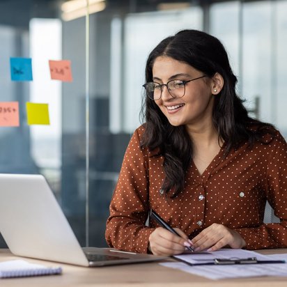 Frau arbeitet am Laptop und erstellt Brandschutzordnungen